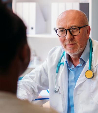 Doctor with stethoscope attentively listens to patient in office
