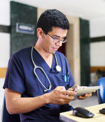 Male healthcare professional using a tablet in a hospital setting