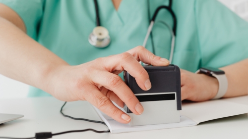 Healthcare professional stamping documents at a desk