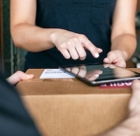 Person signing for package delivery using a tablet device