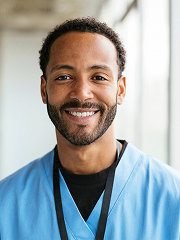Smiling healthcare professional in blue scrubs standing indoors