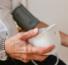 Person monitoring blood pressure with a digital device at home